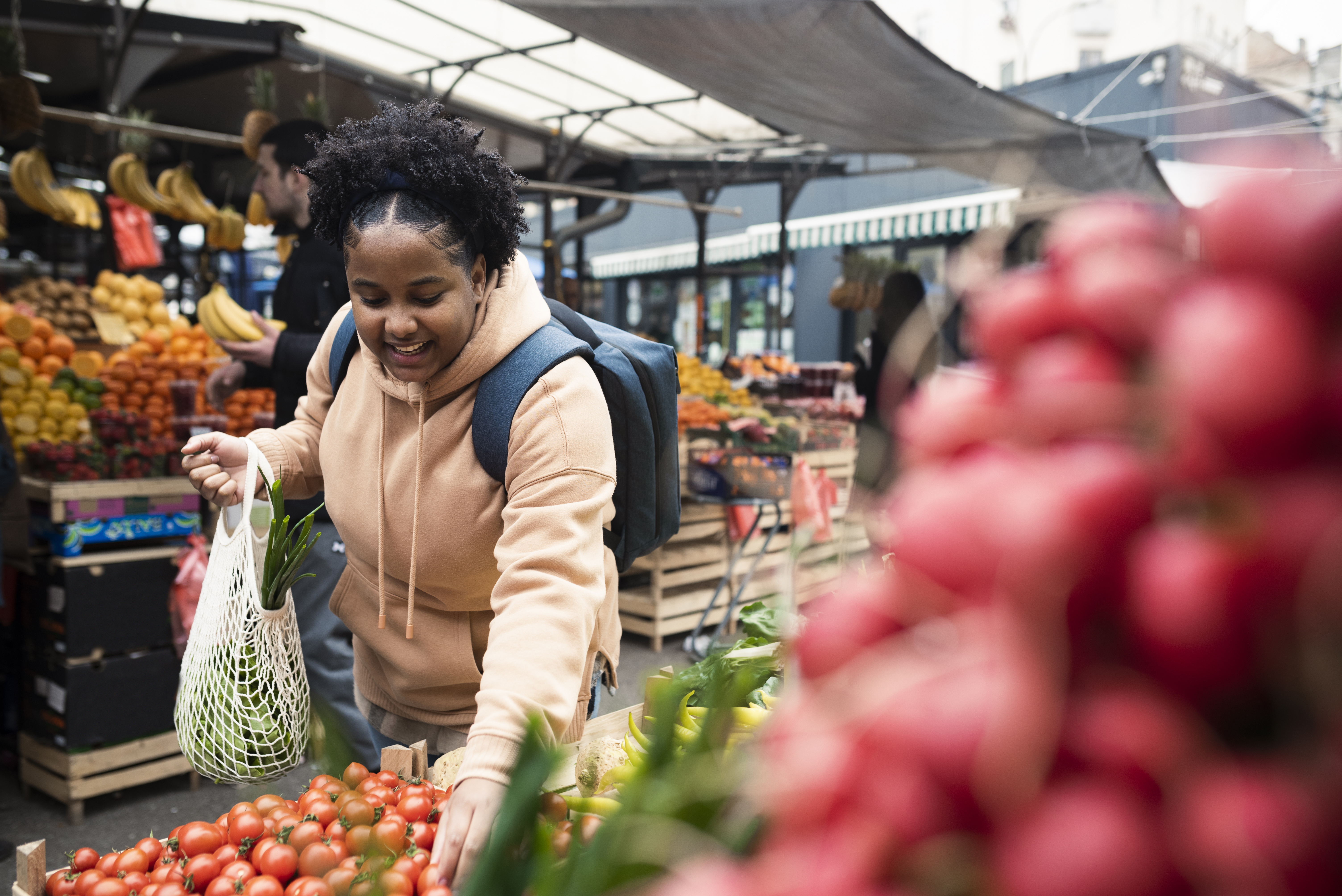 Young black woman shopping at an outdoor fruit and vegetable market