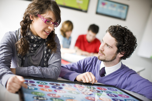 A teacher and student looking at phonemic chart