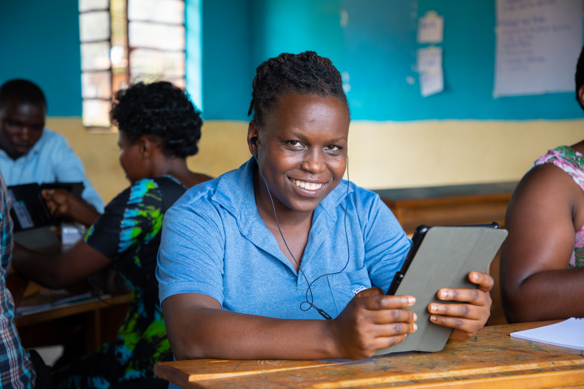 Woman smiling, holding tablet 