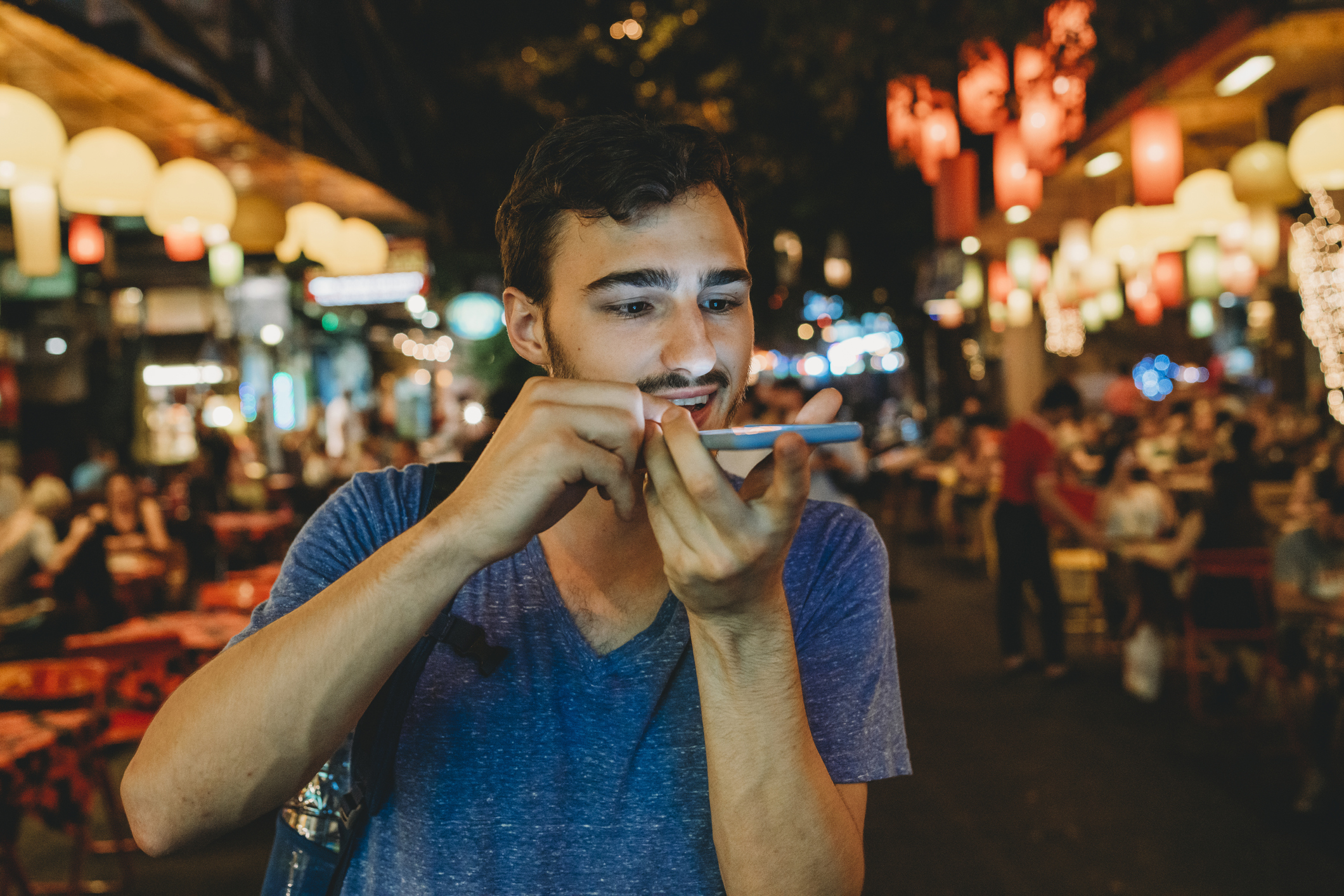 Man in an Asian market speaking into a mobile phone