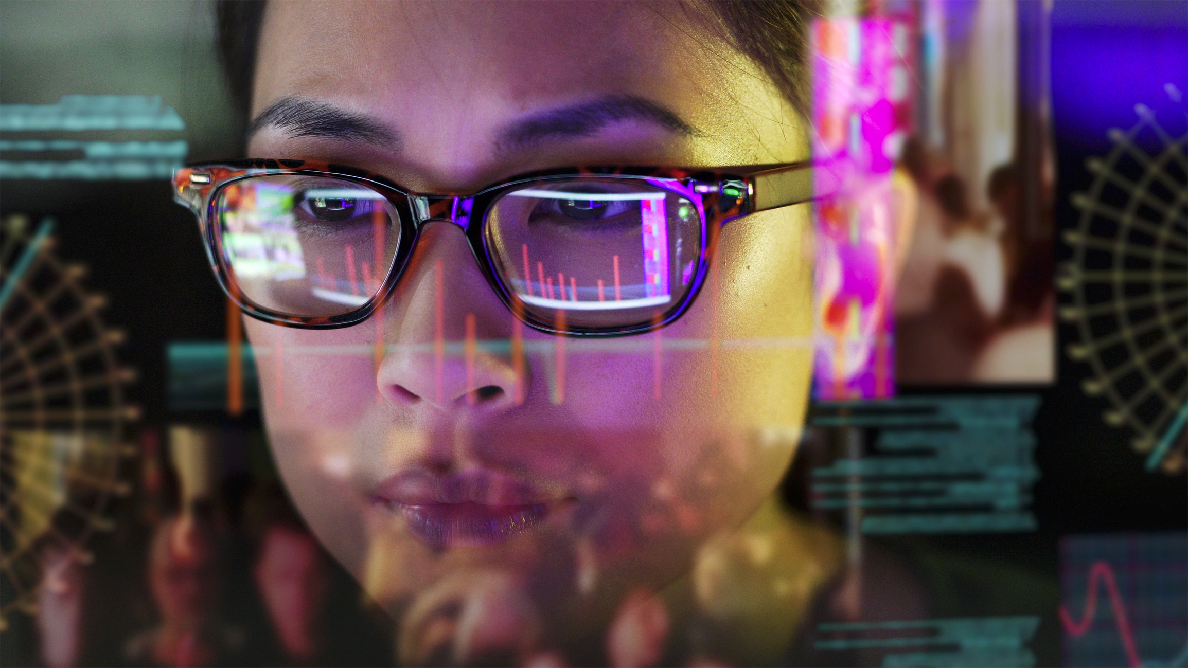 Woman with computer screen reflected in her glasses