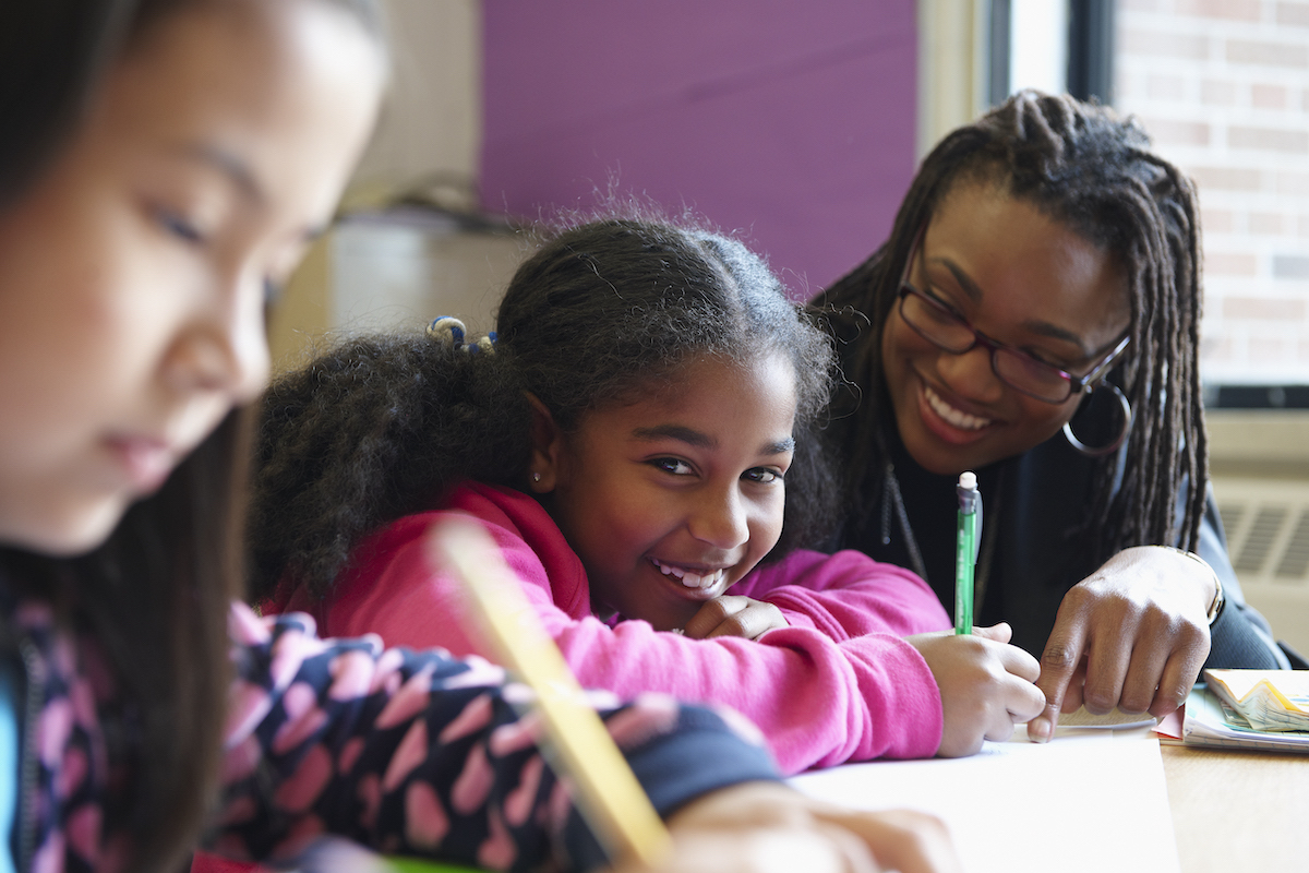 Child and adult happily writing