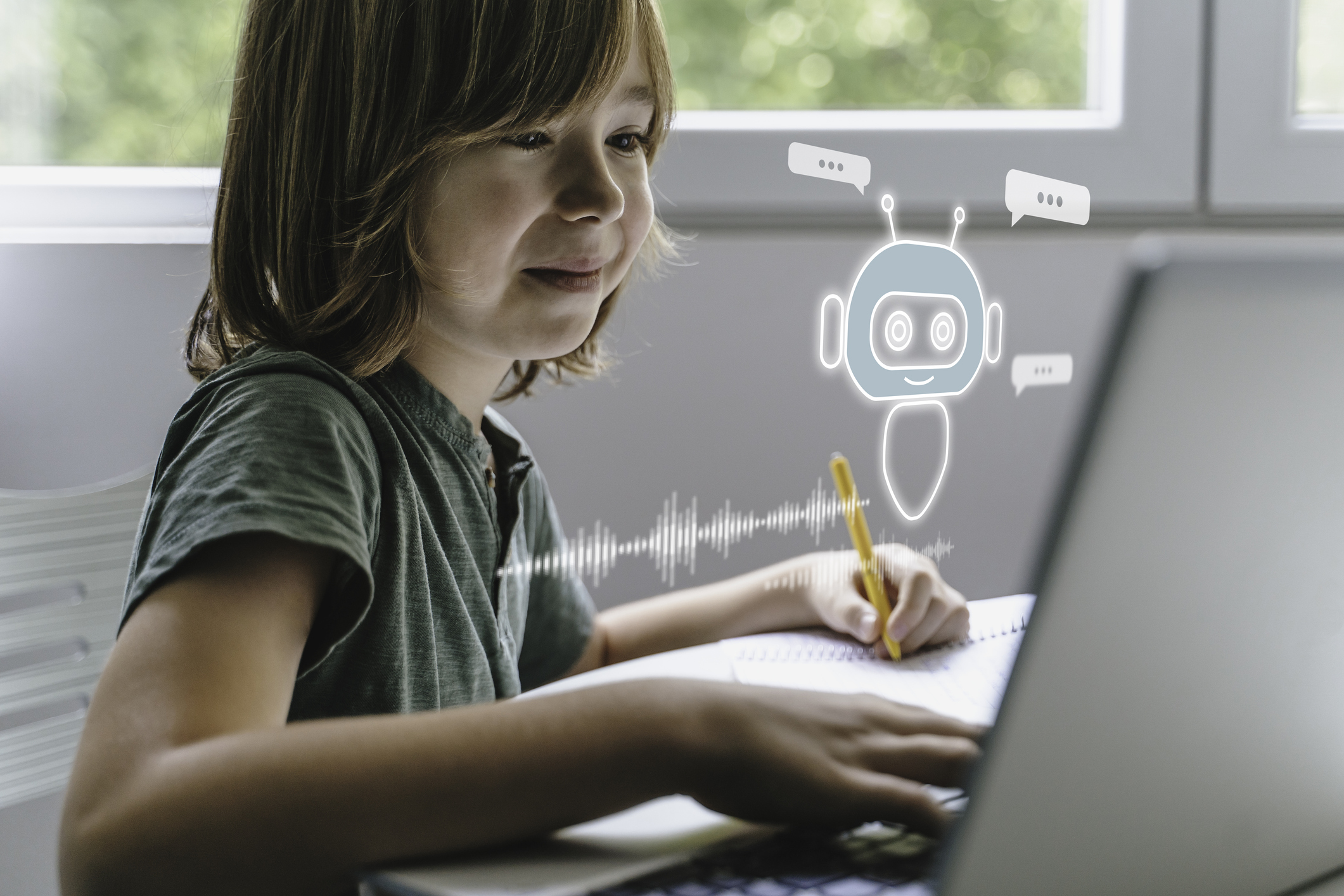 A young boy interacting with a chatbot which is coming out of a computer screen