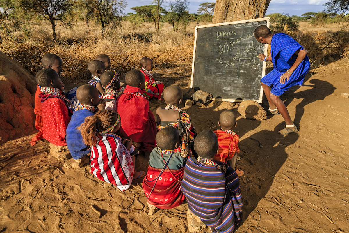 students and students doing class outside with blackboard