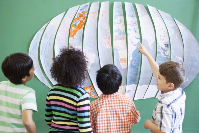 Children standing in front of a map of the world