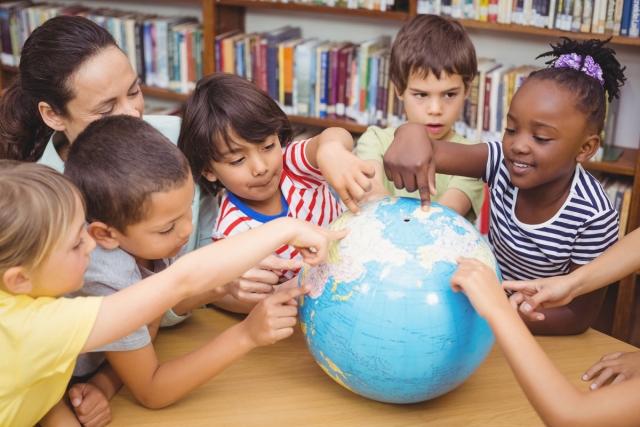 Children pointing at a globe