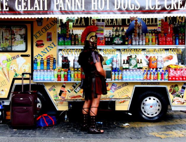 A man dressed up as a Roman soldier in front of an ice cream van