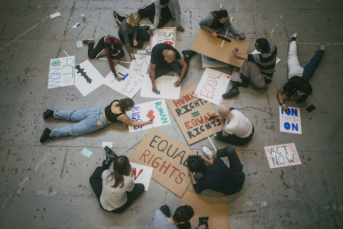 Aerial photo of a group of protesters writing signs for a demonstration