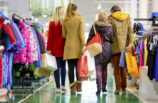 Four people in a clothes shop with shopping bags