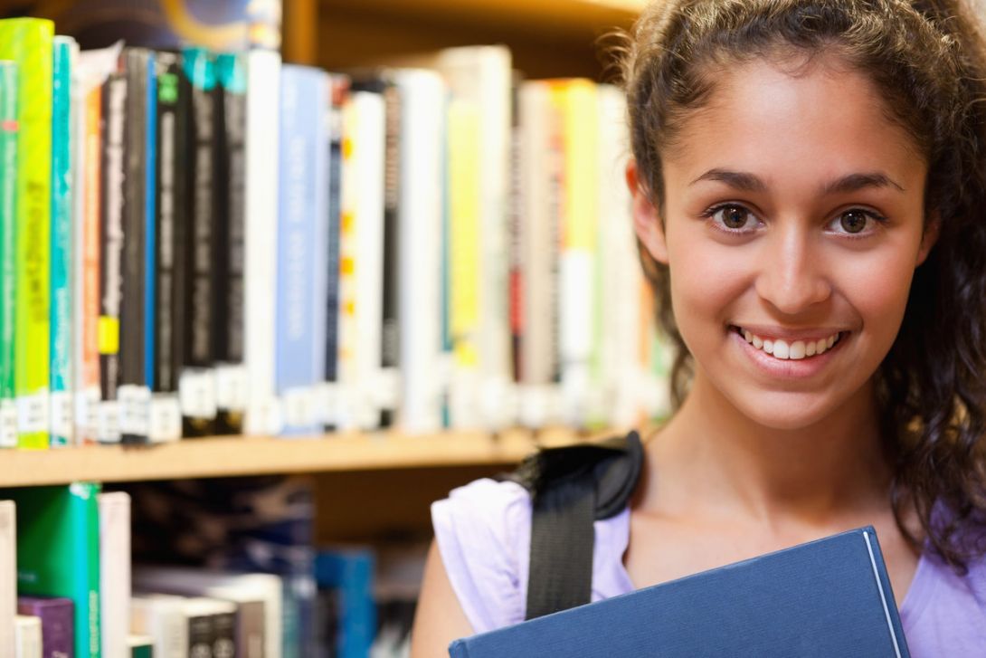 A smiling girl standing in a library