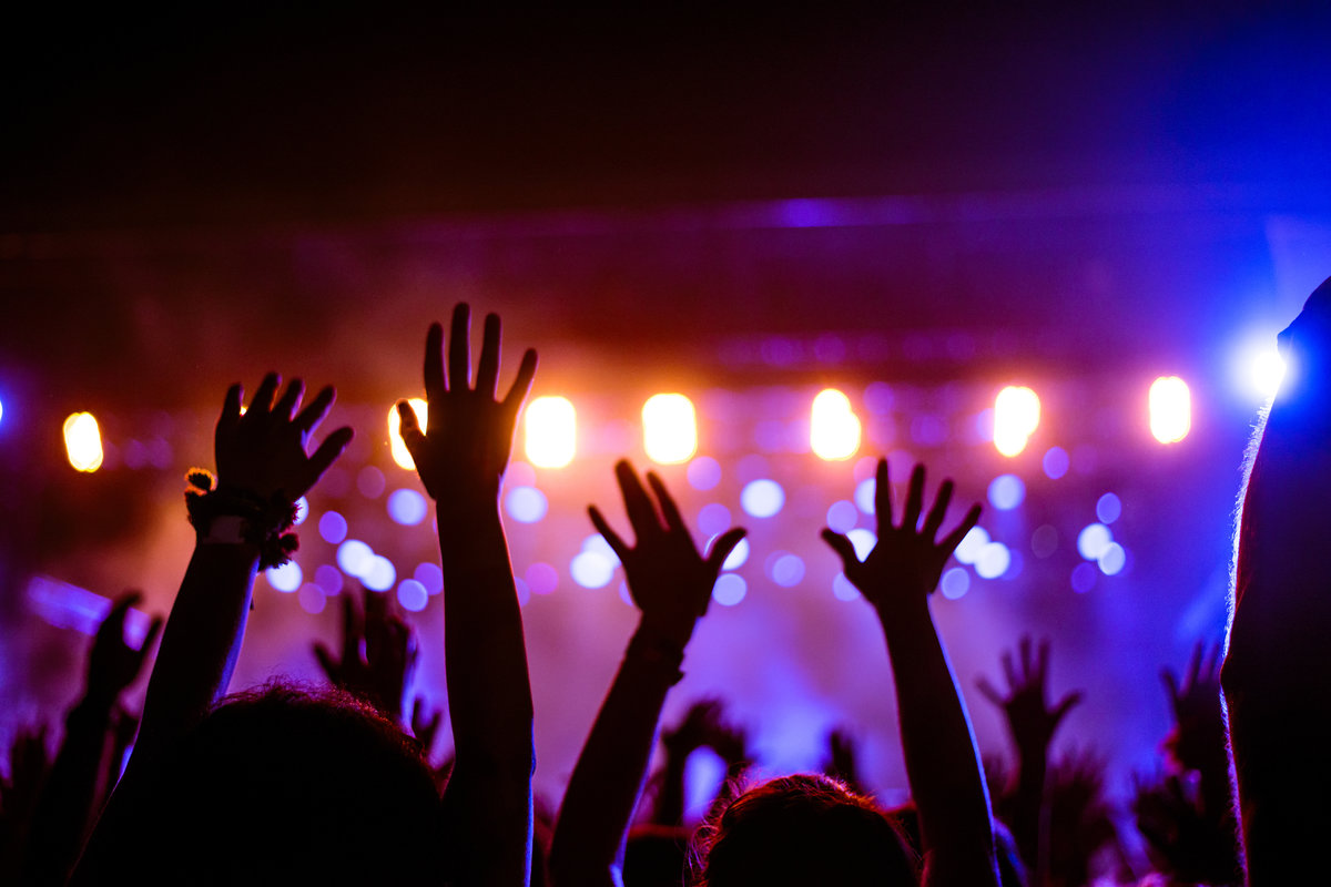 Audience at a music festival with hands in the air