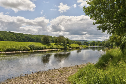 Scene of English countryside with river and green fields