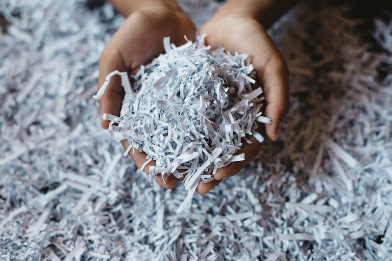 Close up of hands holding shredded paper