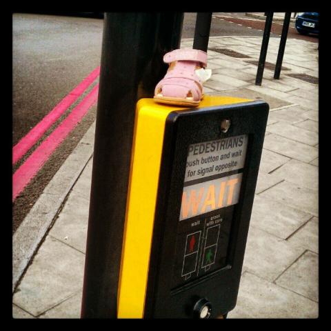 A child's pink shoe at a pedestrian crossing