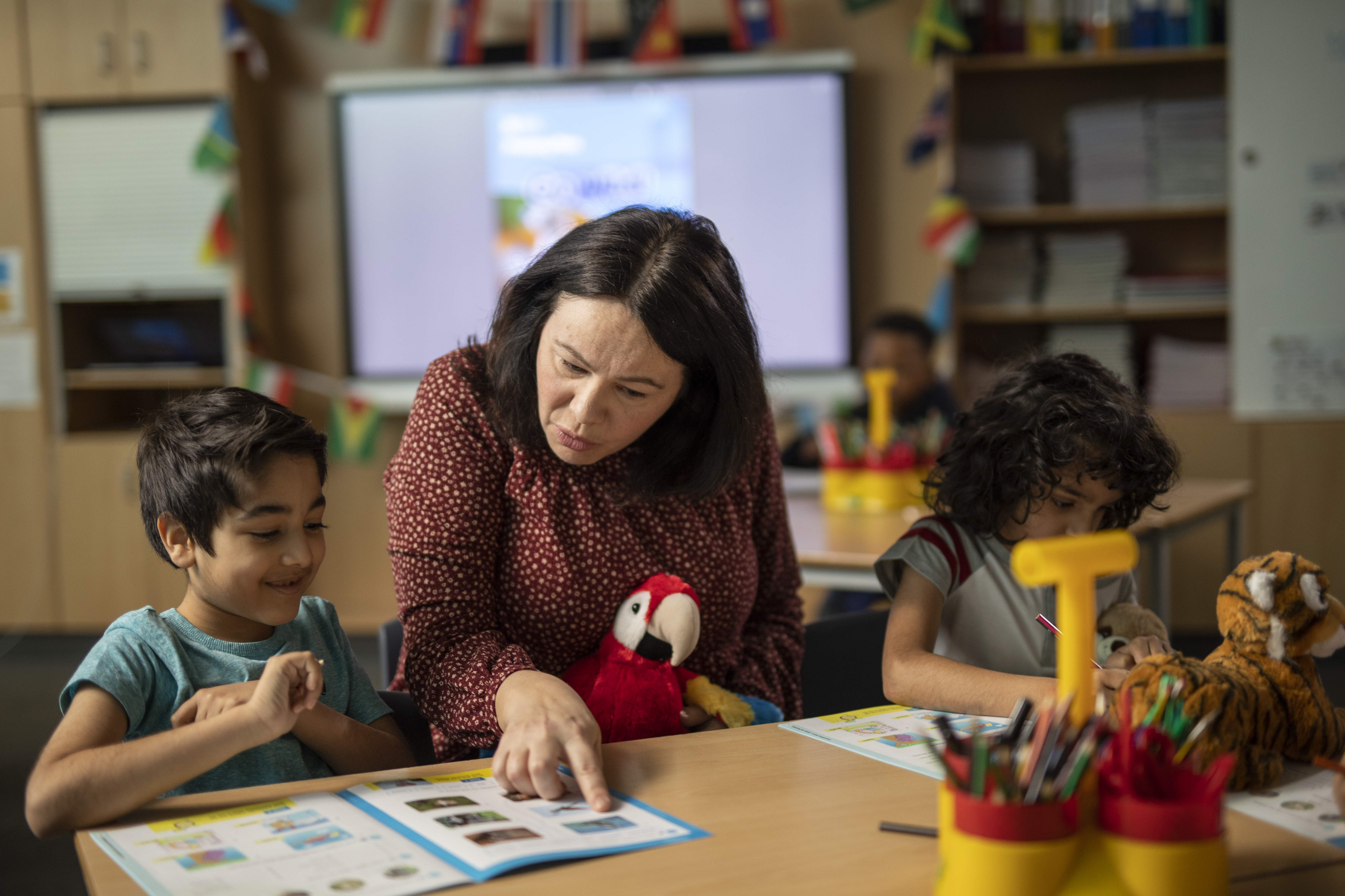 Young learners in classroom with toys and learning aids