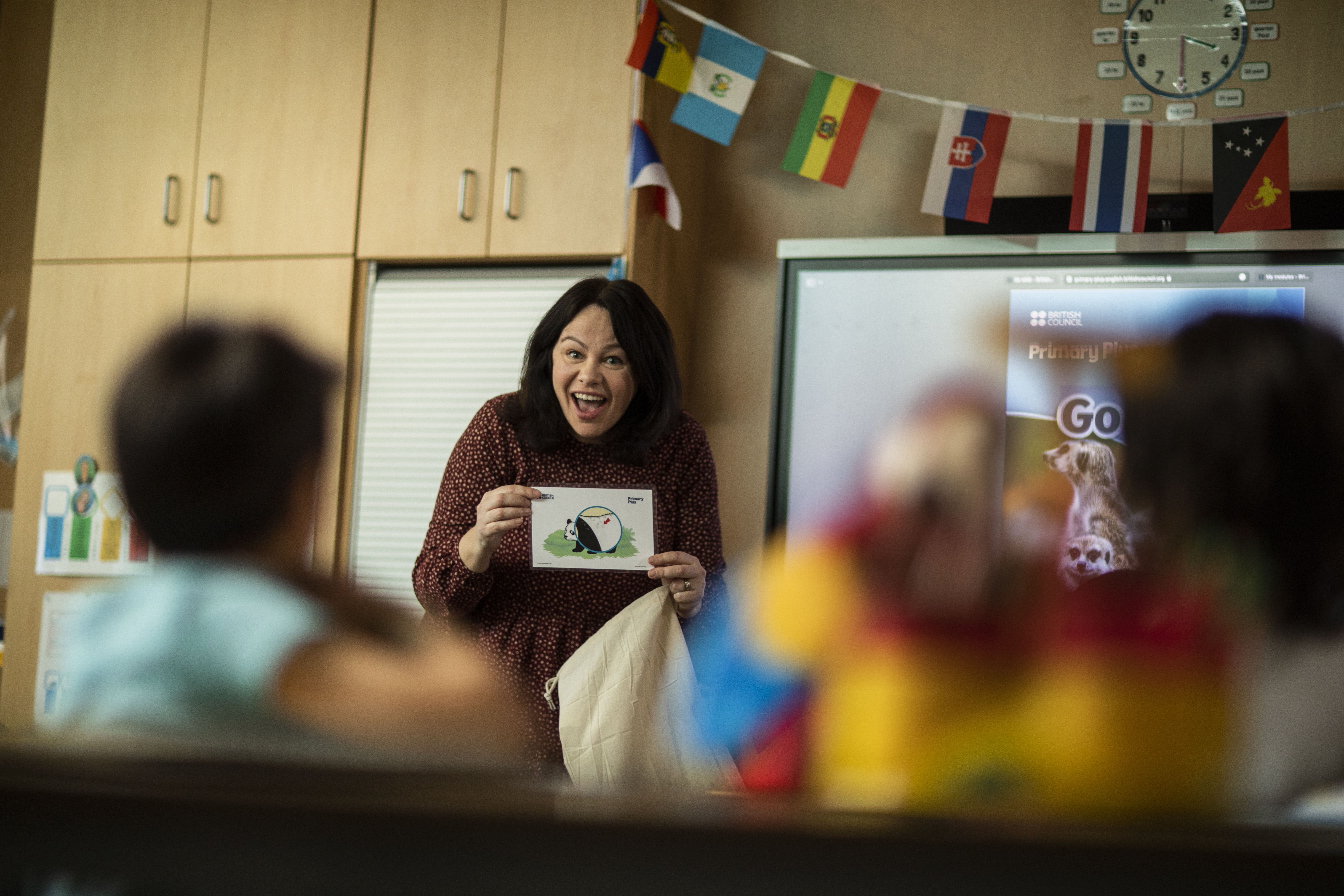 teacher showing flashcard to young learners