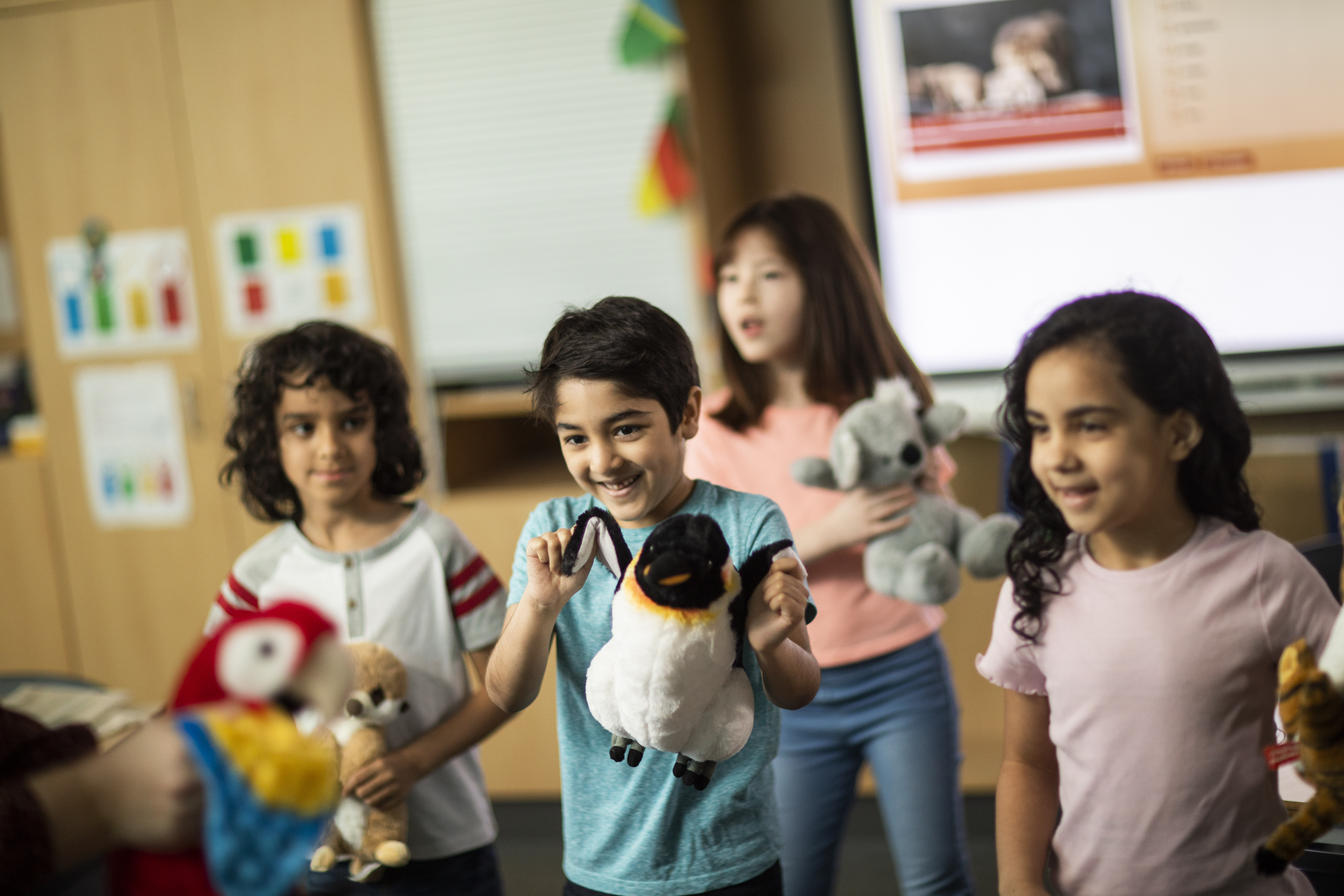 Young learners playing with soft toy animals