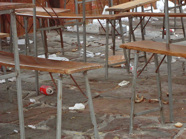 Table and chairs surrounded by rubbish.