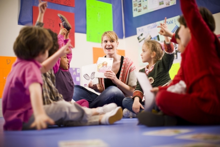 a teacher showing flashcards to young learners