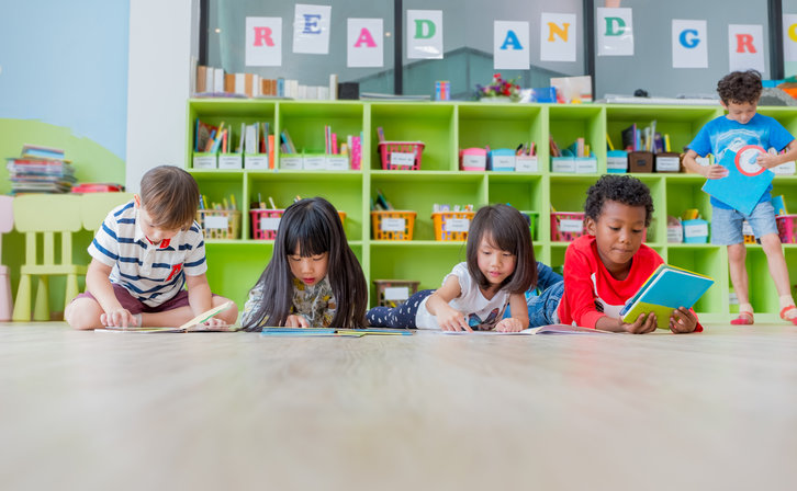 Five children looking at picturebooks in a library