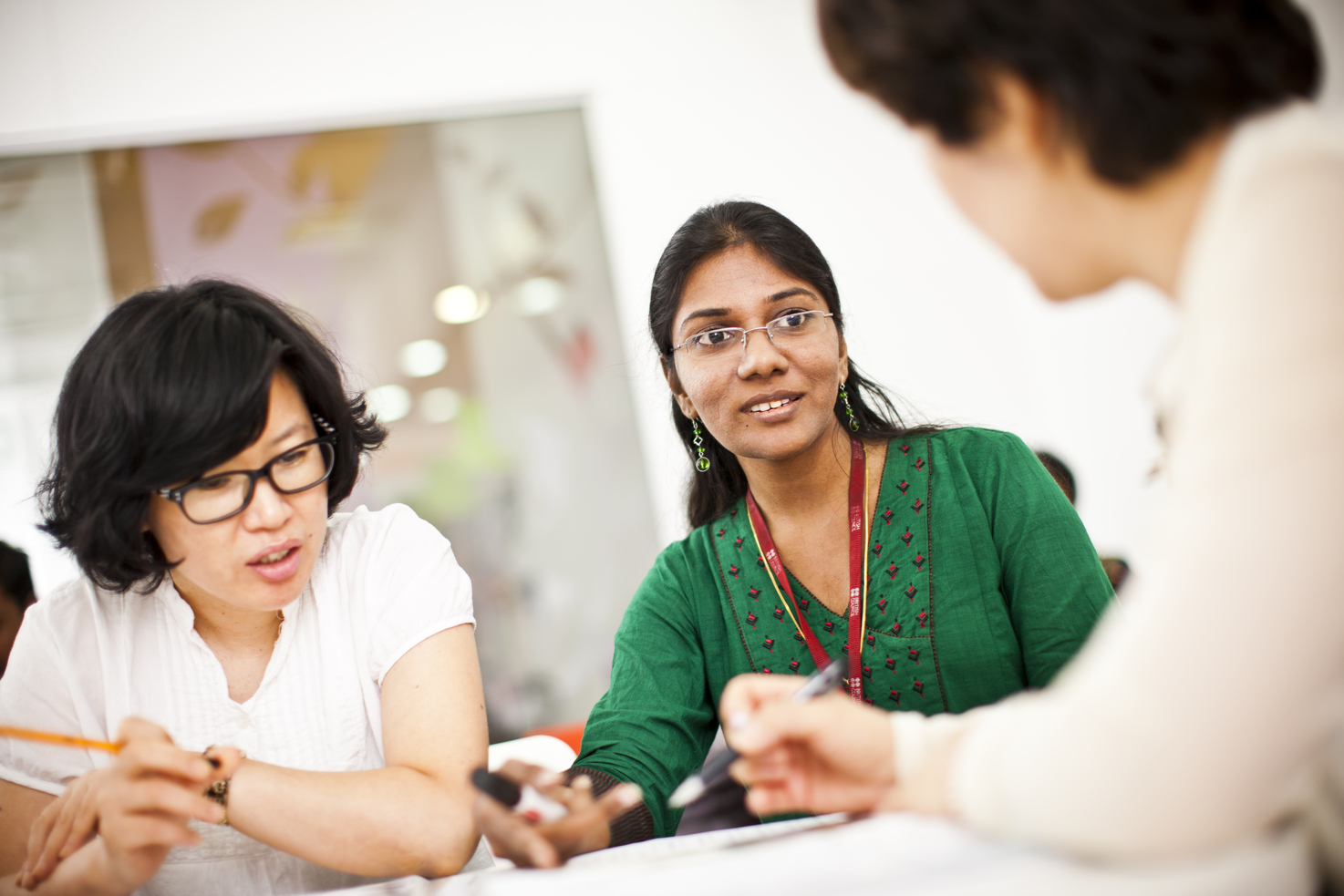 Three teachers discussing at a table