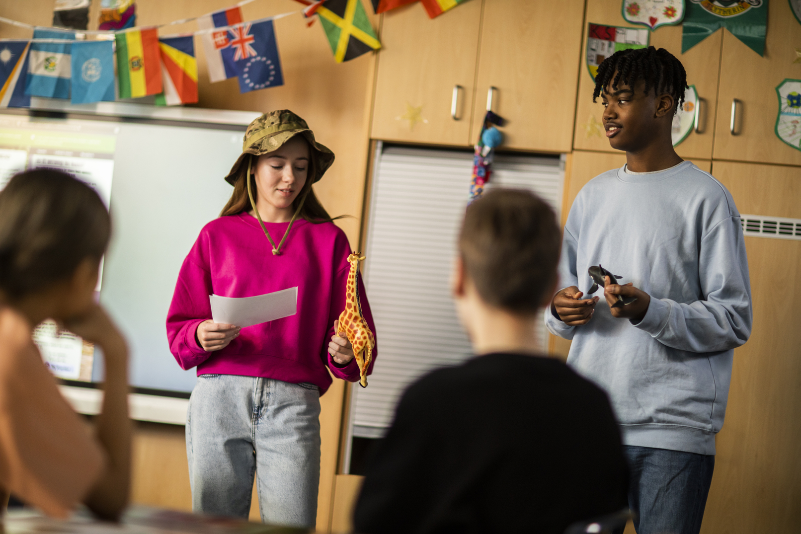 Teenage students acting out a travel story in front of their peers