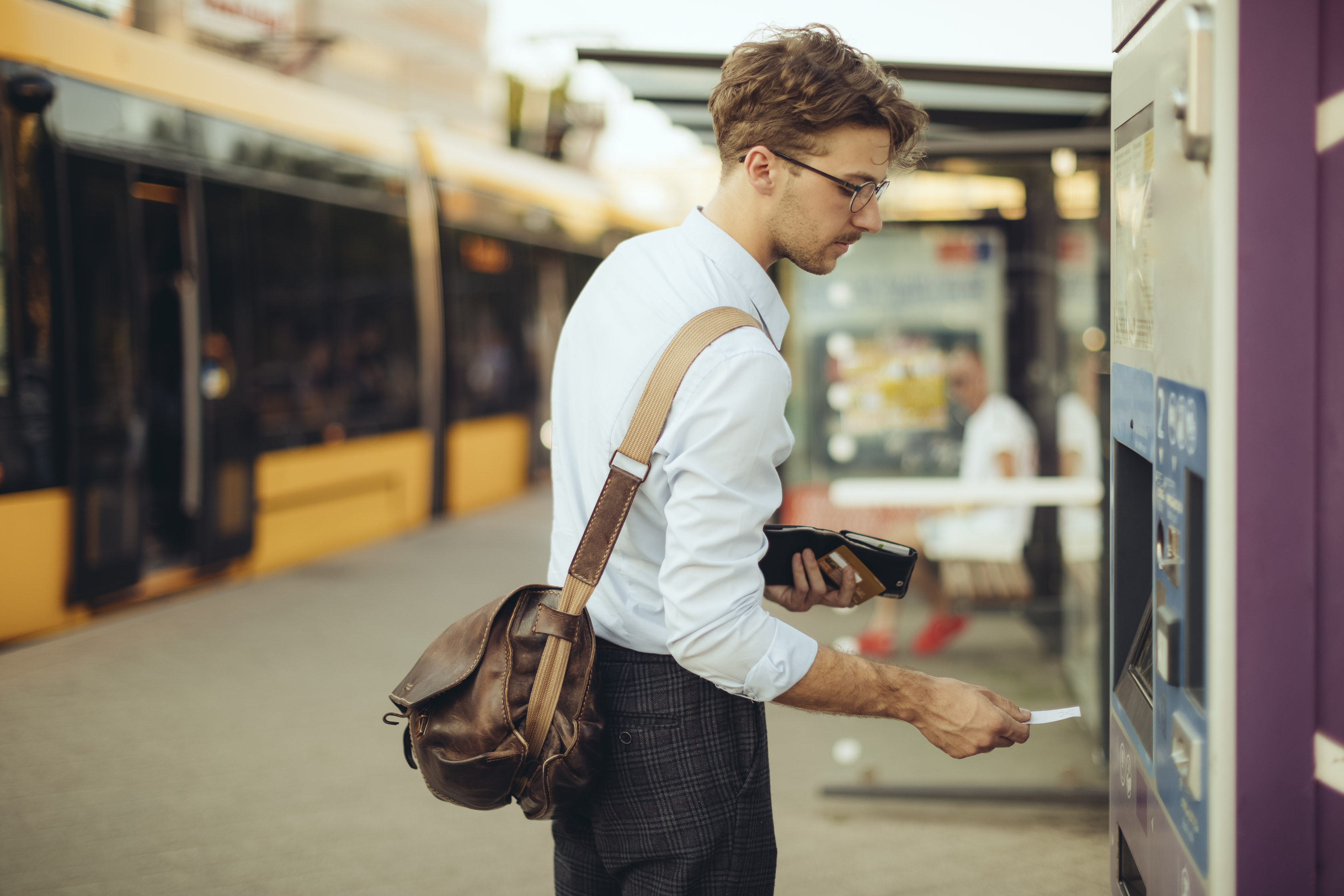 A man buys a train ticket at a machine in train station