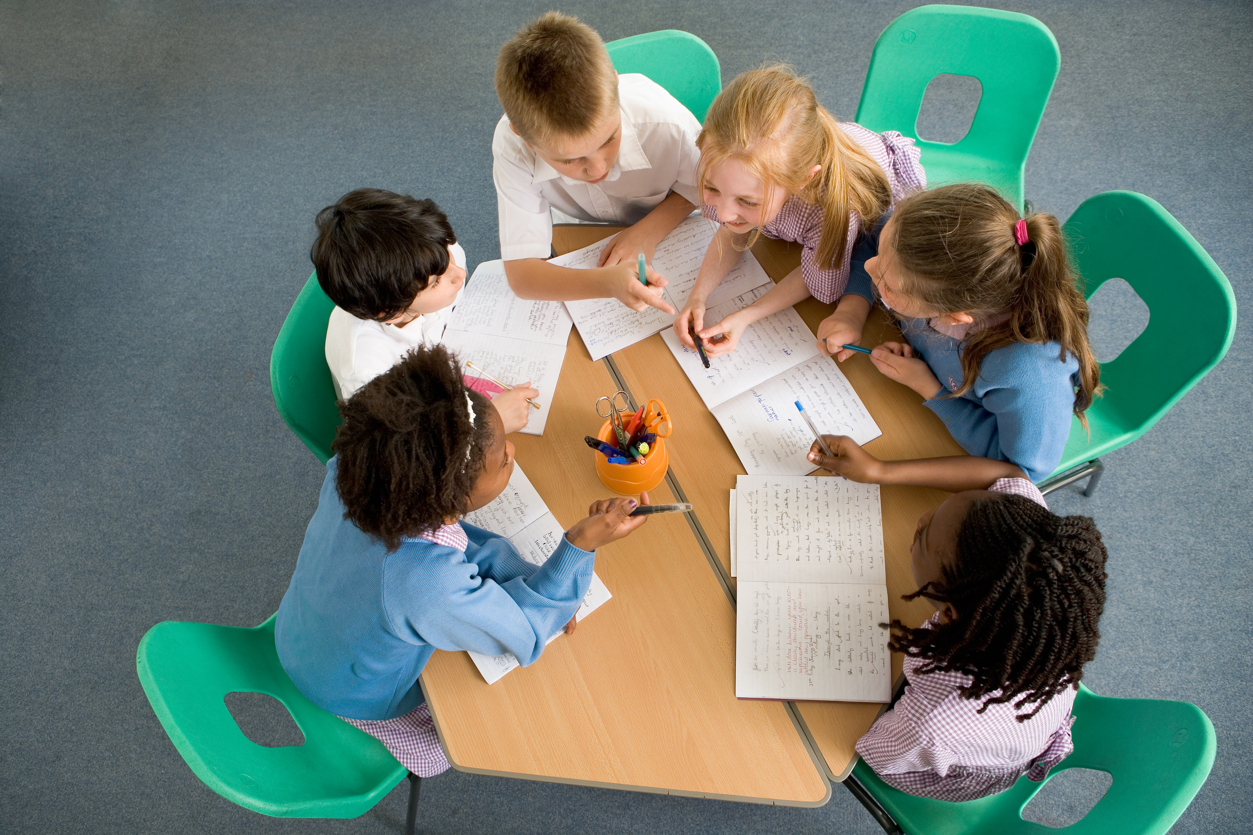 Group of young learners working together at a table in classroom