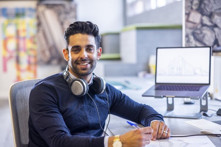 man looking at camera with headphones around his neck