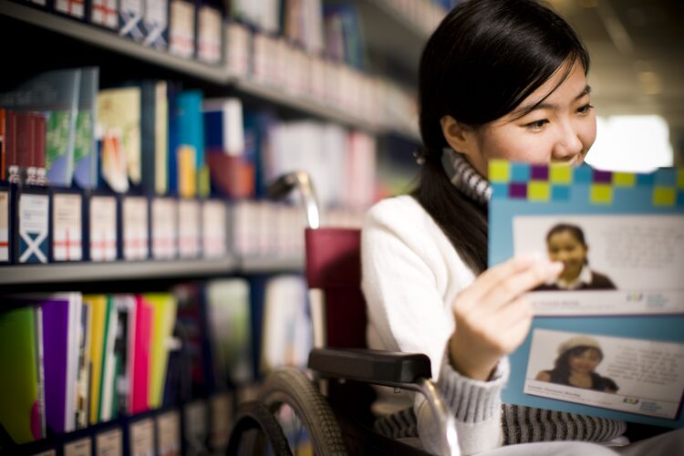 woman in library reading a report