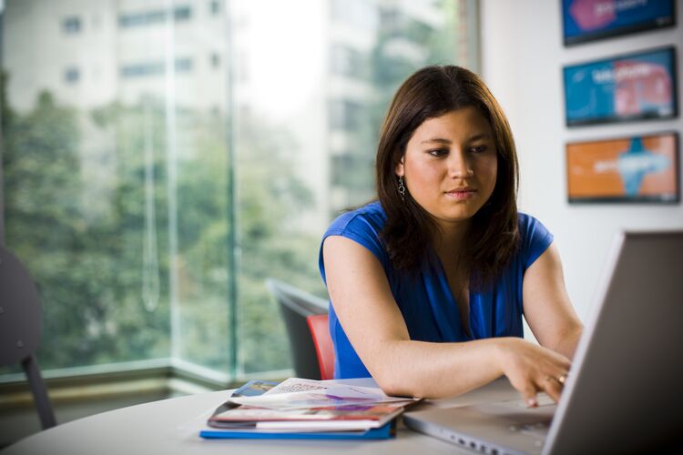 woman in blue dress typing on laptop