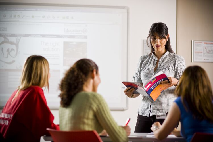 Teacher in classroom in Colombia talks to students