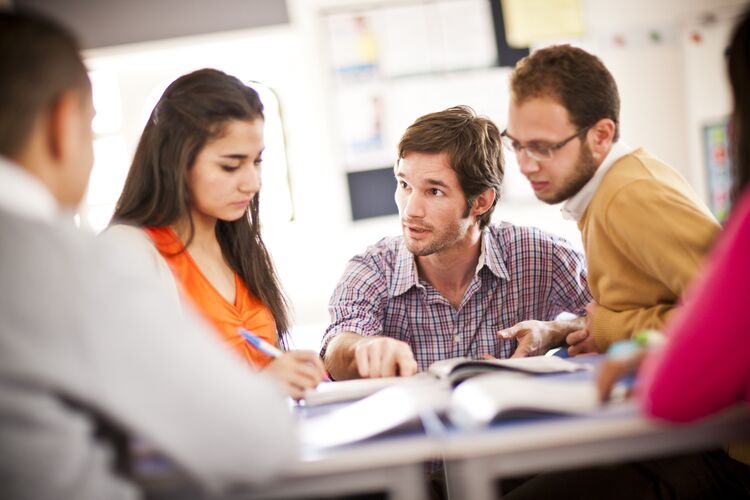 Teacher speaking to students at a table