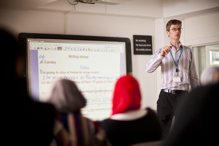 Teacher standing in front of class at whiteboard