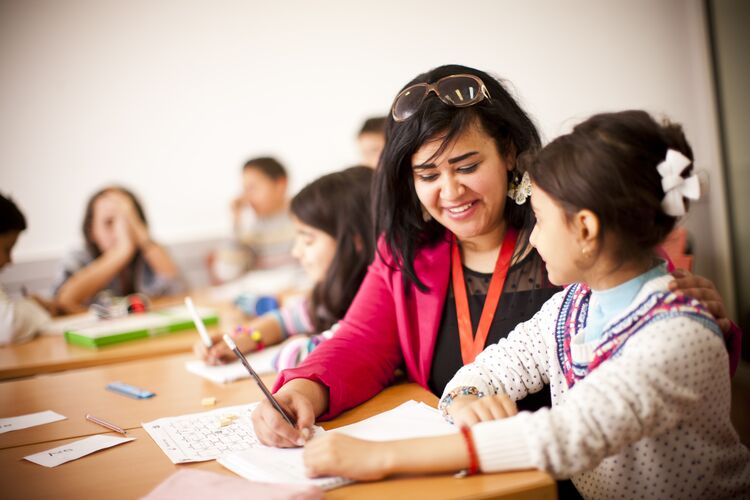 A teacher in Egypt helping a student with writing