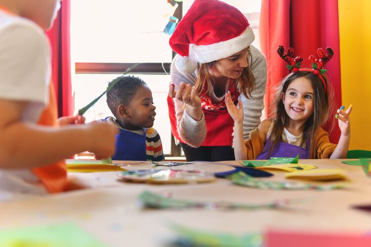 Young learners and a teacher making Christmas crafts