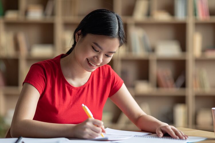 Female Asian learner studying in a library