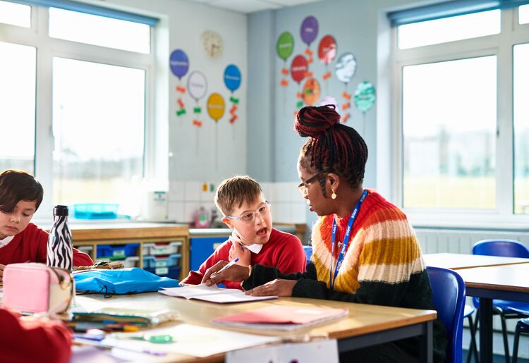 Female teacher helping a boy with special educational needs