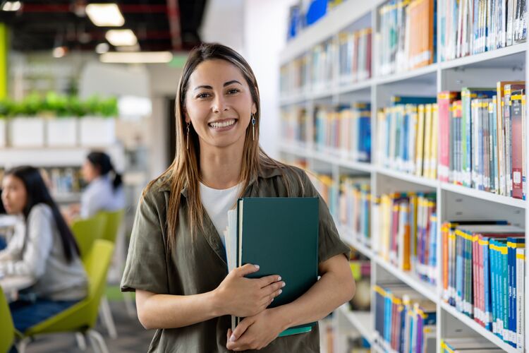 Woman holding books in a library