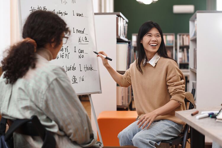 Woman smiling and writing on whiteboard