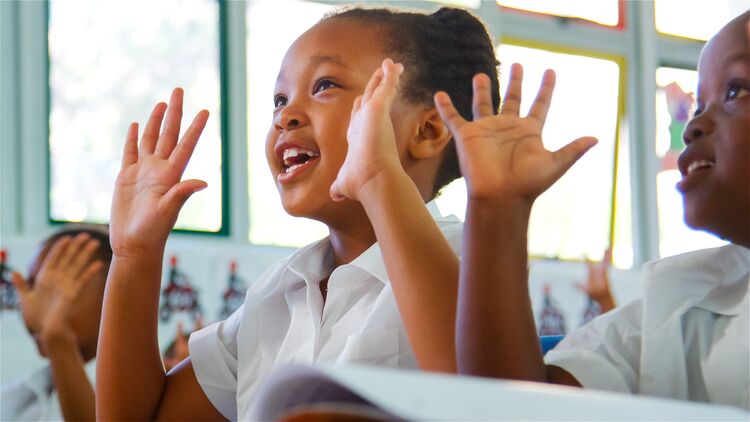 Young learners signalling with their hands in the classroom