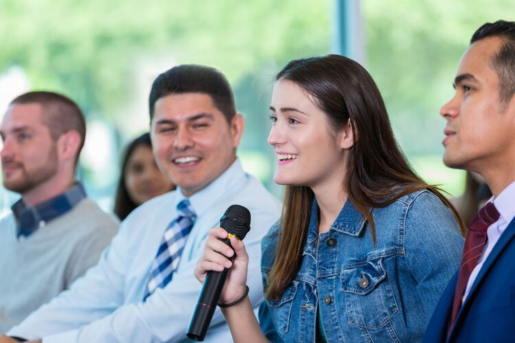 A young woman asking a question at an event