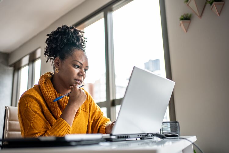 Black woman teacher studying on her laptop