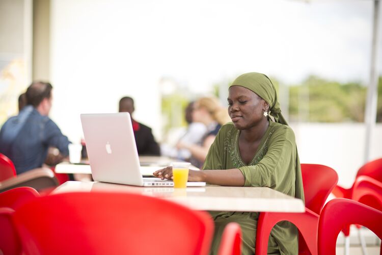 woman in green dress looking at laptop