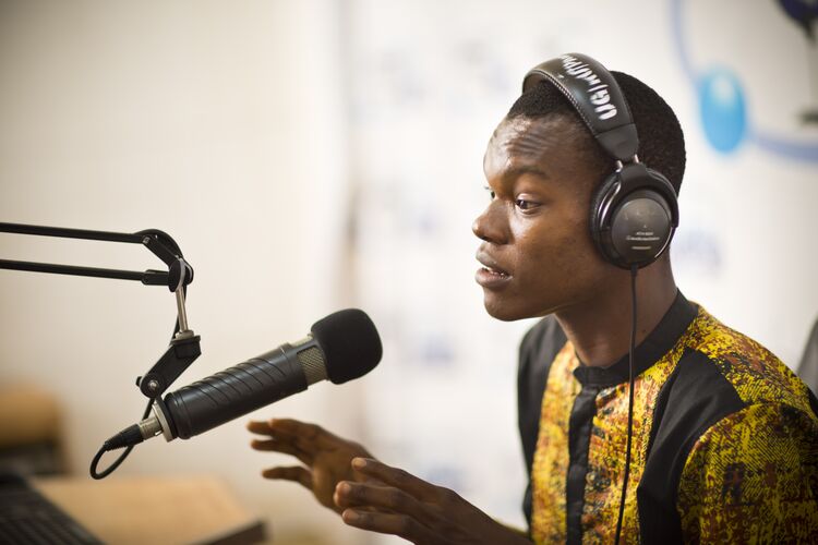 Presenter speaking into a mic on Ghana radio station