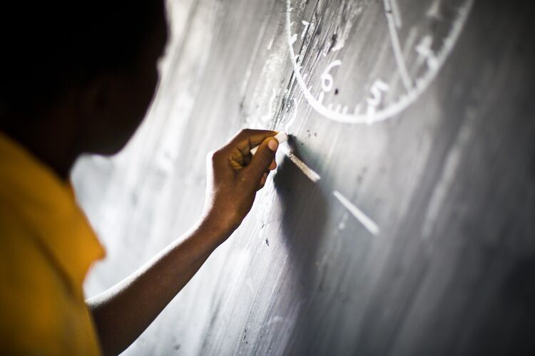 Boy writing on a blackboard