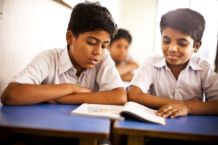 Two students working together in a classroom in India