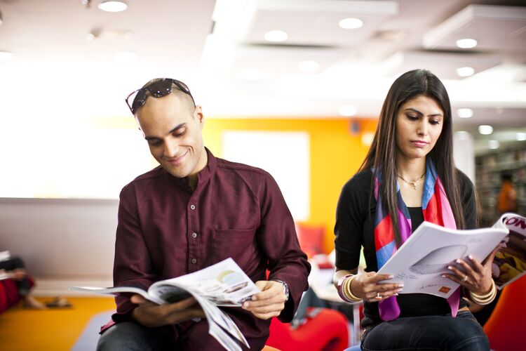 Two students reading magazines