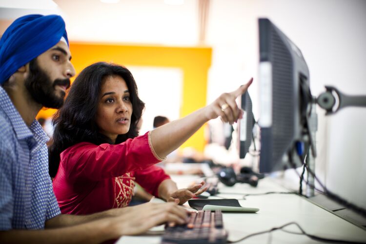 Male and female students in India working together on a computer