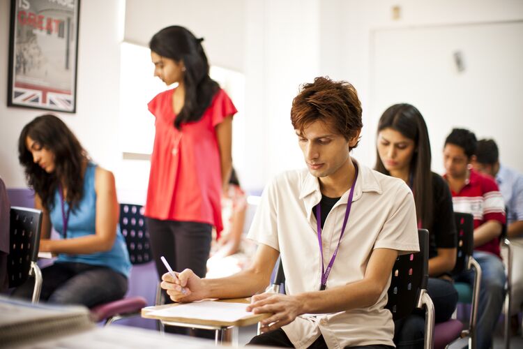 Students sitting at desks taking a test in classroom in India